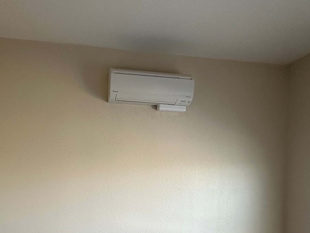 A ductless mini split head mounted in a bedroom